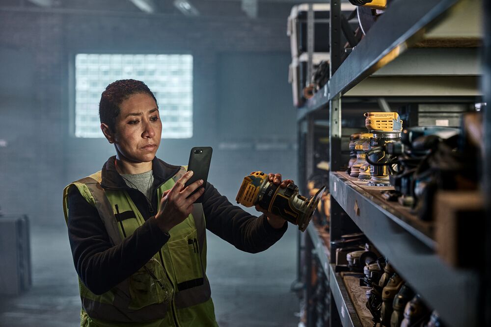A woman is taking a picture of the DEWALT MATRIX™ Jig Saw Attachment for the Cordless Drill.
